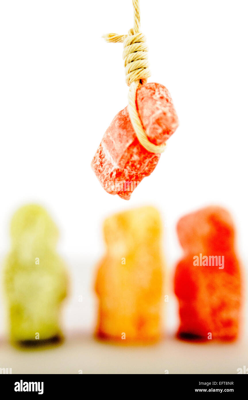 Jelly babies look on as one jelly baby is hanged by a noose. Stock Photo