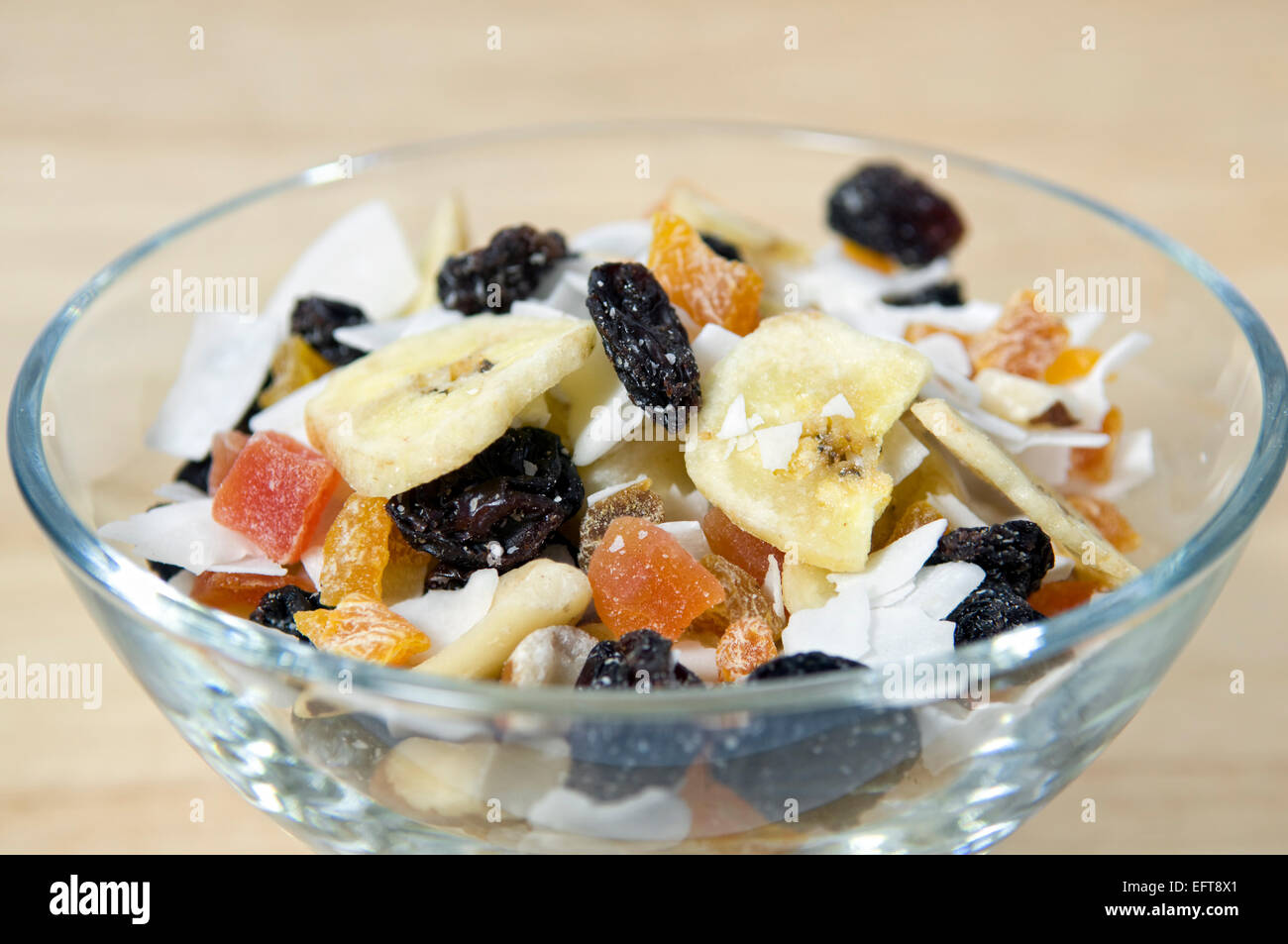 Close up of dried fruit, nut and coconut, or trail mix, in glass bowl Stock Photo