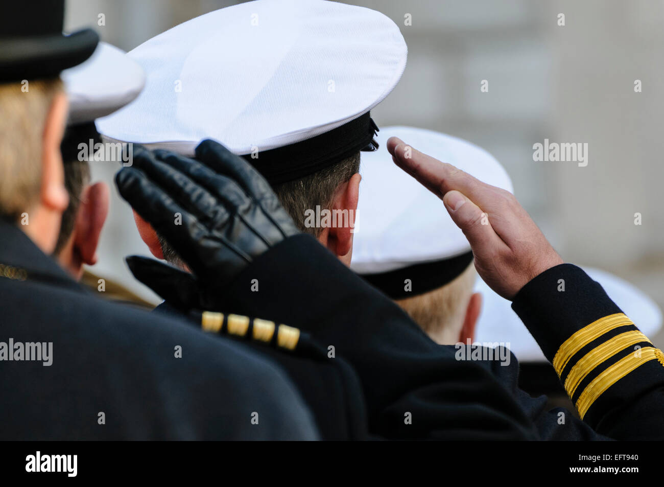 Royal Navy officers salute during Remembrance Day commemorations. Stock Photo