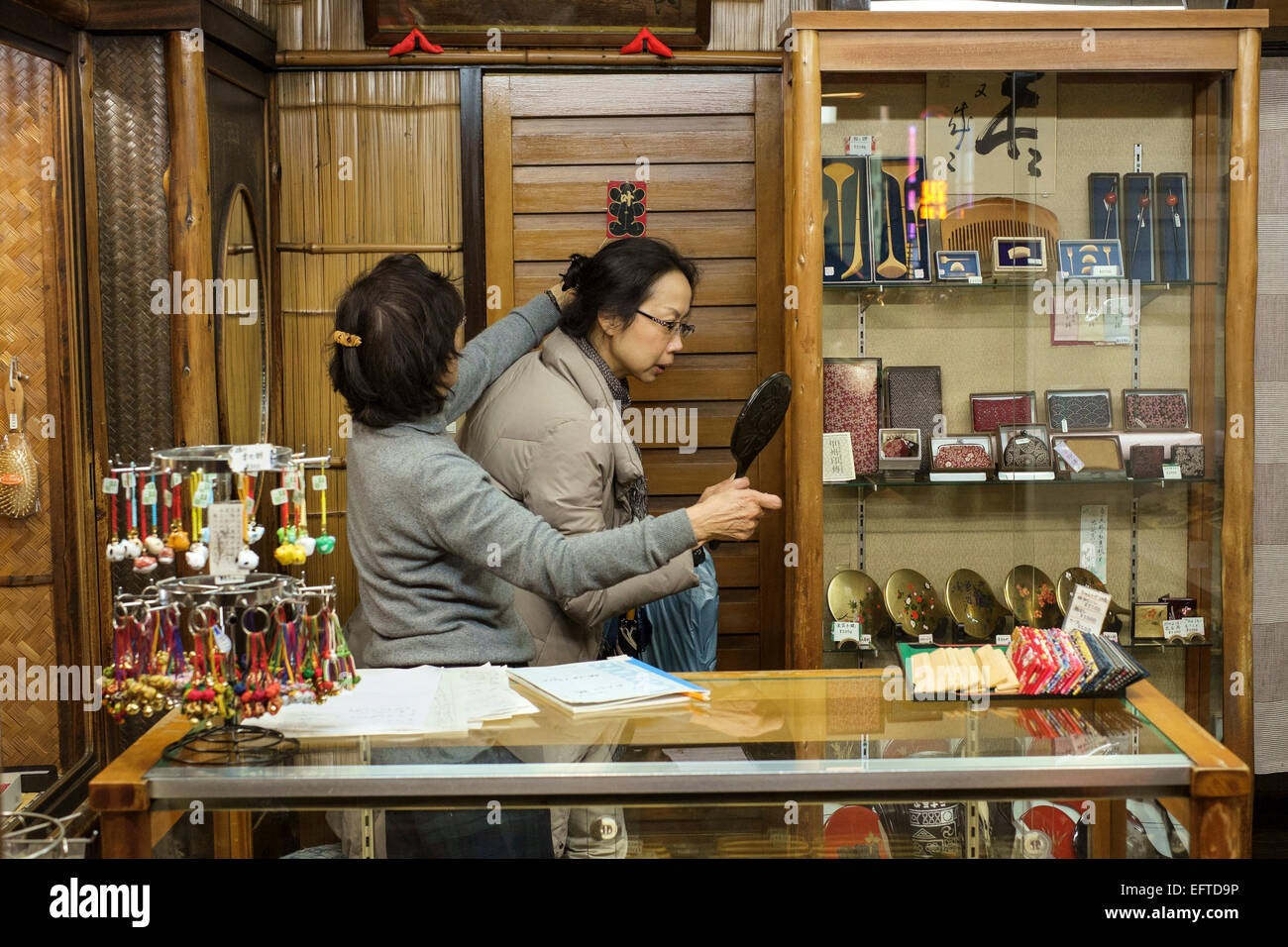 Japan - Kyoto - woman inspecting hair accessory in a small store on Shijo Kawaramachi Stock Photo