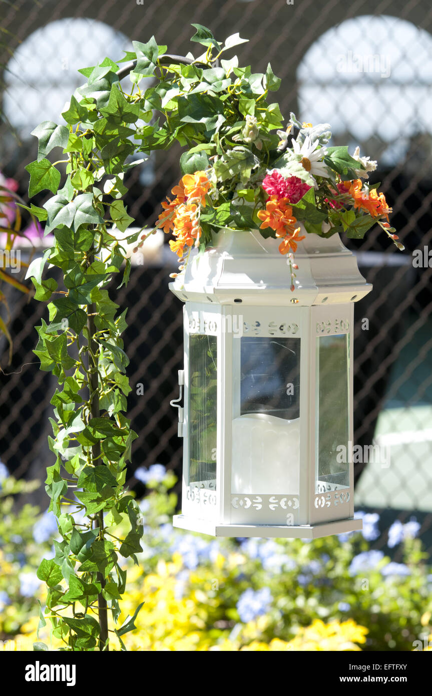 Candle holder. It is an enclosed "cage" hanging from a plant stand