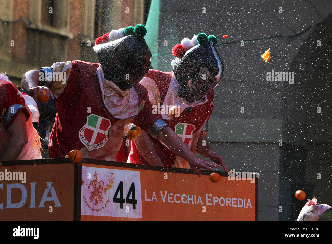 Two participants being targeted by oranges as part of the 'Battle of the Oranges' at the Ivrea carnival. Stock Photo