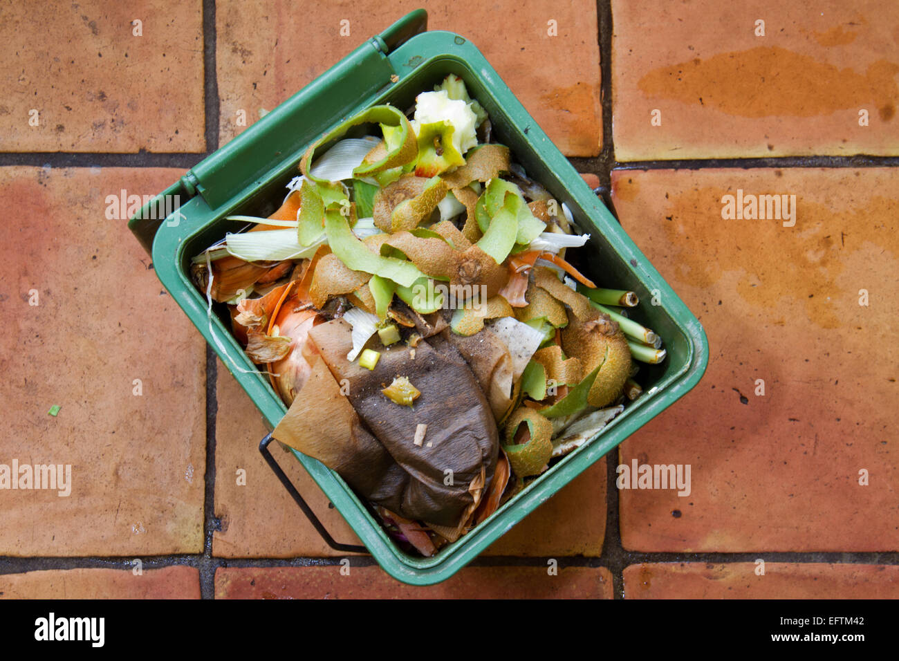 Compost bucket, filled with peels, coffee filters, etc. on a kitchen