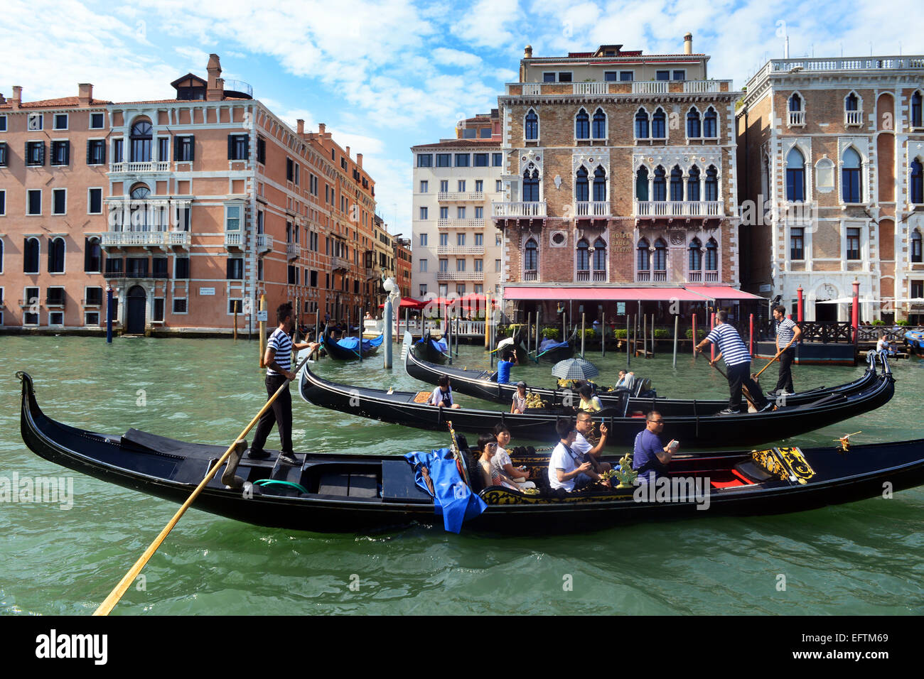 Gondolier steers his gondola up and down the Grand Canal, Venice Italy. Stock Photo