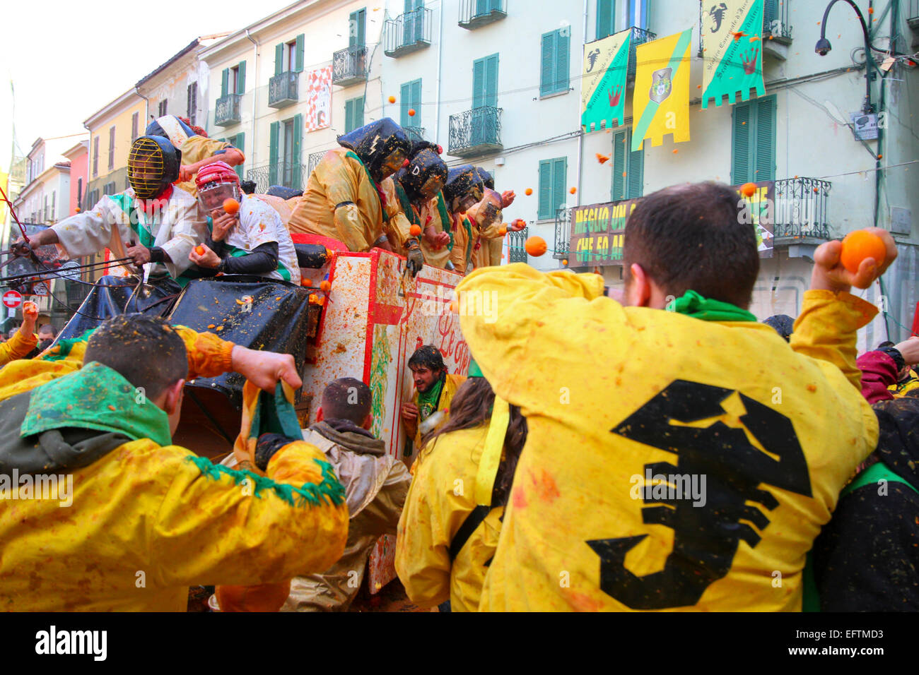 Orange throwers struggle to reach the enemy cart as part of the 'Battle of the Oranges' at Ivrea Carnival. Stock Photo