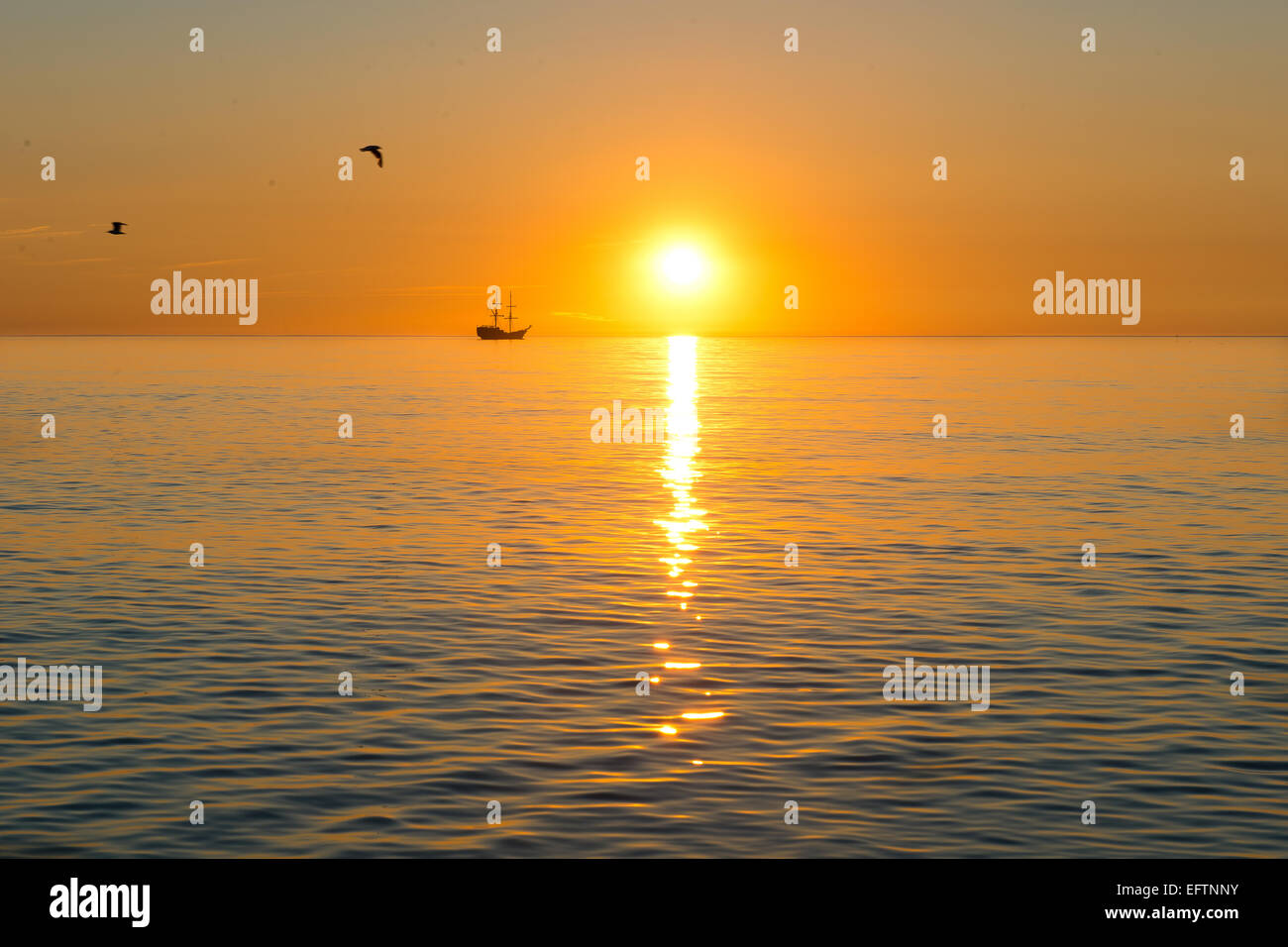 sunset - sailing ship silhouette on the sunset background Stock Photo ...