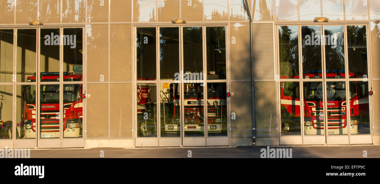 Fire trucks behind glass doors at fire station garage , Finland Stock ...