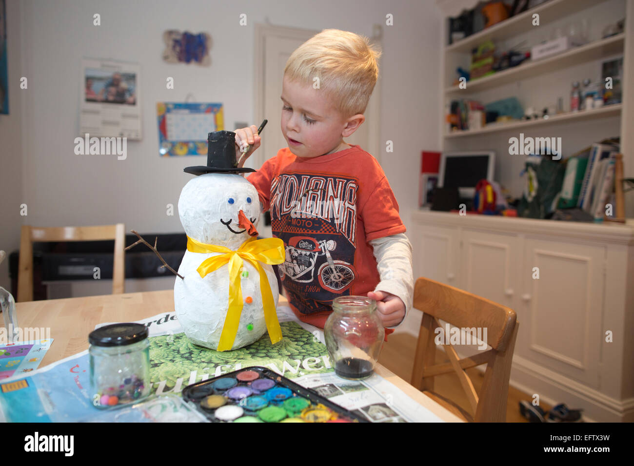Four (4) year old boy making a paper mache, papier måché snowman as part of his school homework, UK Stock Photo