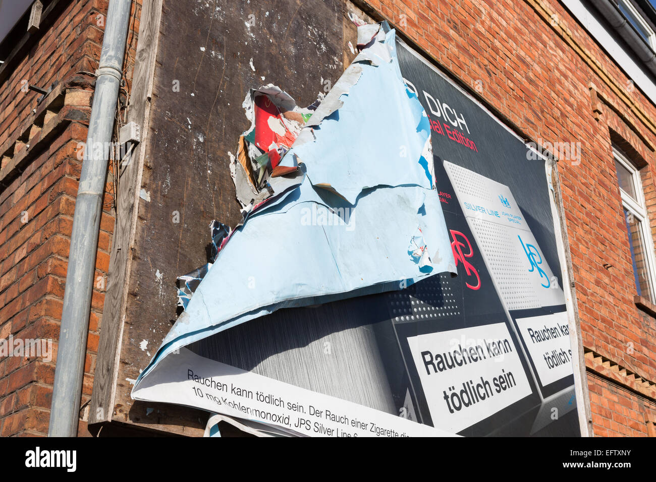 An old, weathered, peeling German advertising billboard attached to the side of a house Stock Photo