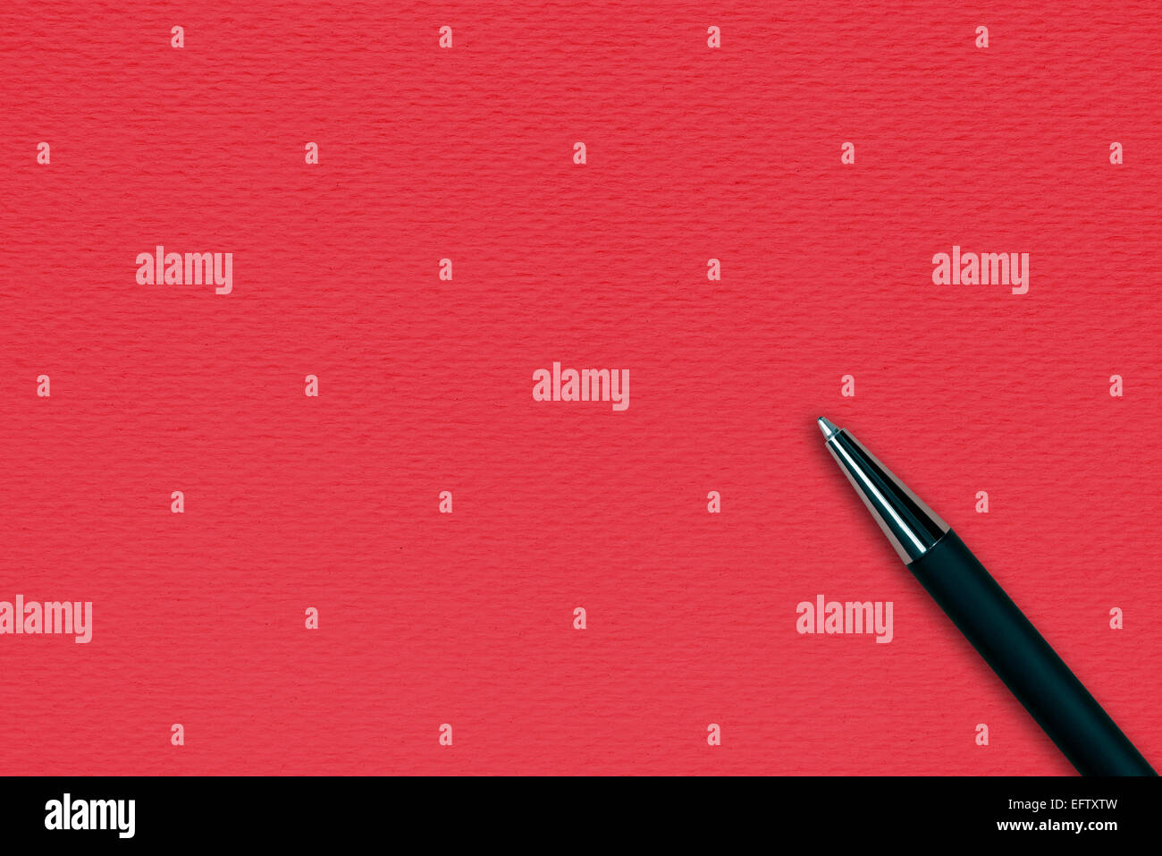 Red paper background with black ball pen and text space Stock Photo