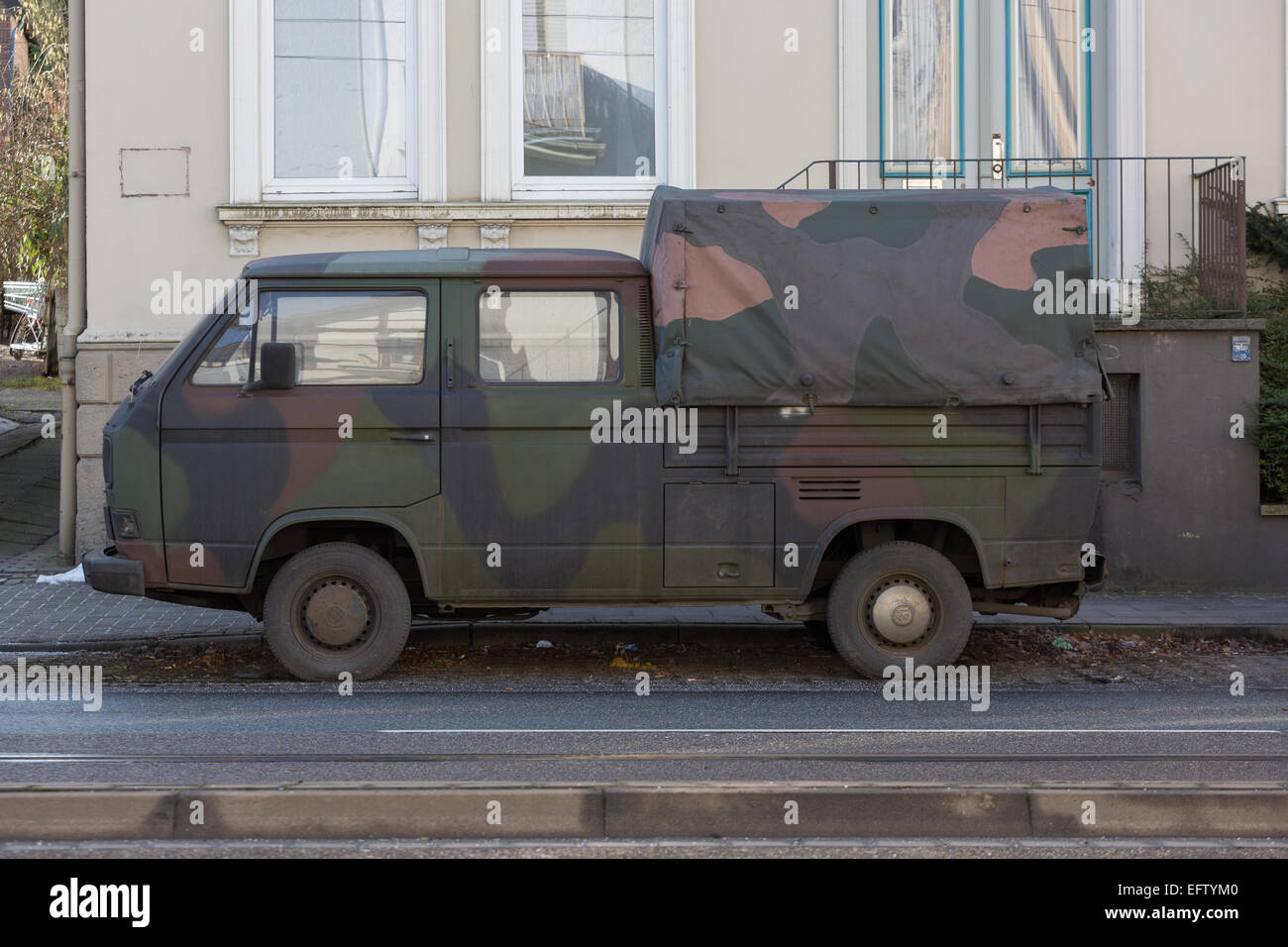 An ex-German military camouflaged vehicle parked in a street Stock Photo