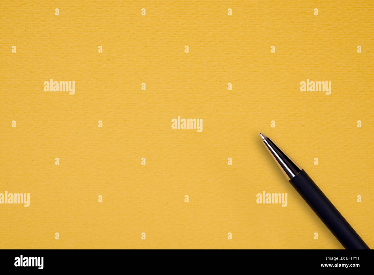 Yellow paper background with black ball pen and text space Stock Photo