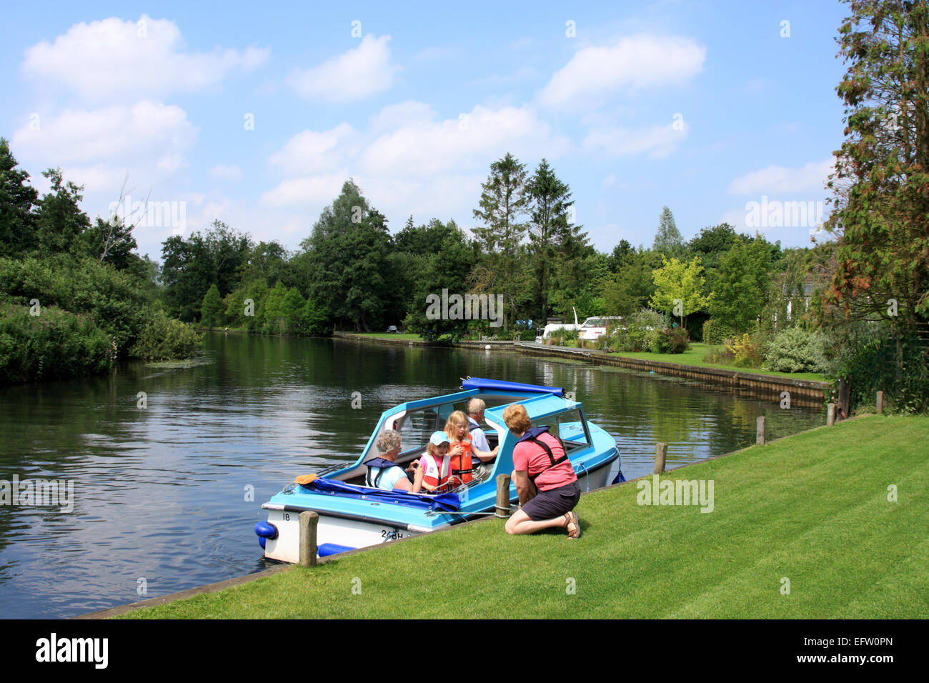 Family outing on a dayboat, seen here moored at Belaugh Staithe on the River Bure, between Hoveton and Coltishall / Norfolk / UK Stock Photo