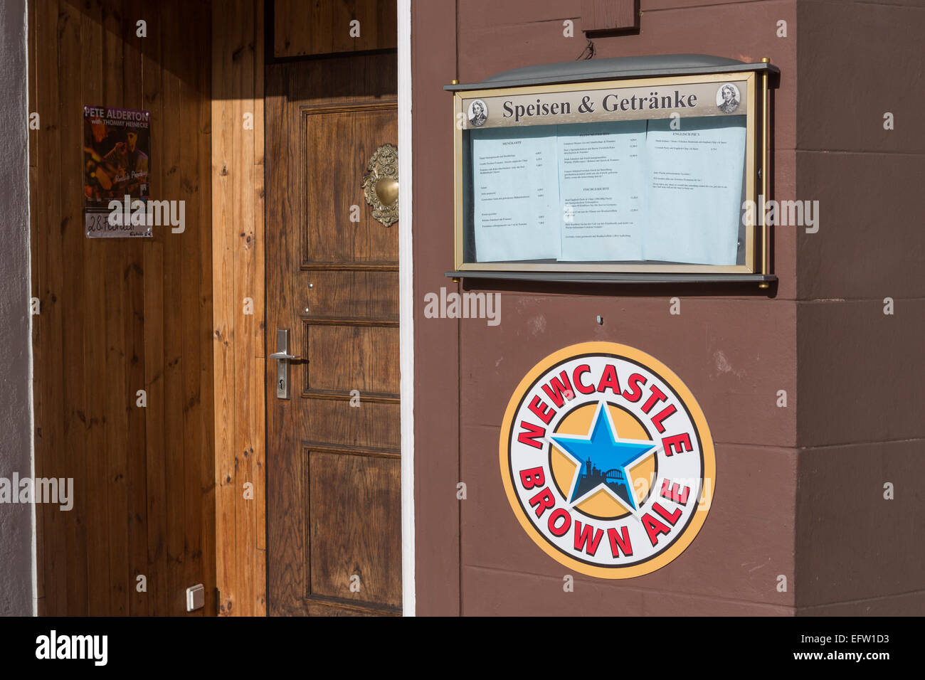 The front of a German restaurant advertises Newcastle Brown Ale below its German menu Stock Photo