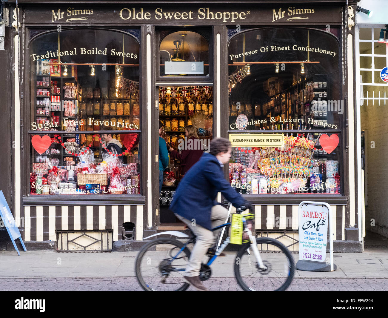 A cyclist rides past Mr Simms Olde Sweet Shoppe Cambridge UK Stock Photo