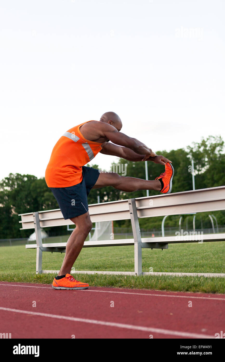 Track and Field Runner Stretching Stock Photo