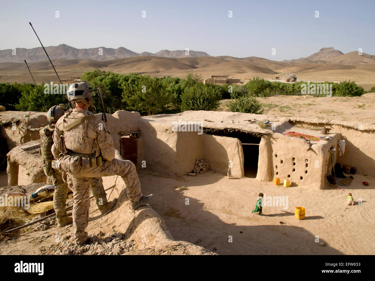 US special force commandos watches mortar rounds land on the outskirts of a village during a clearing operation August 9, 2012 in Shah Wali Kot district, Kandahar province, Afghanistan. Stock Photo