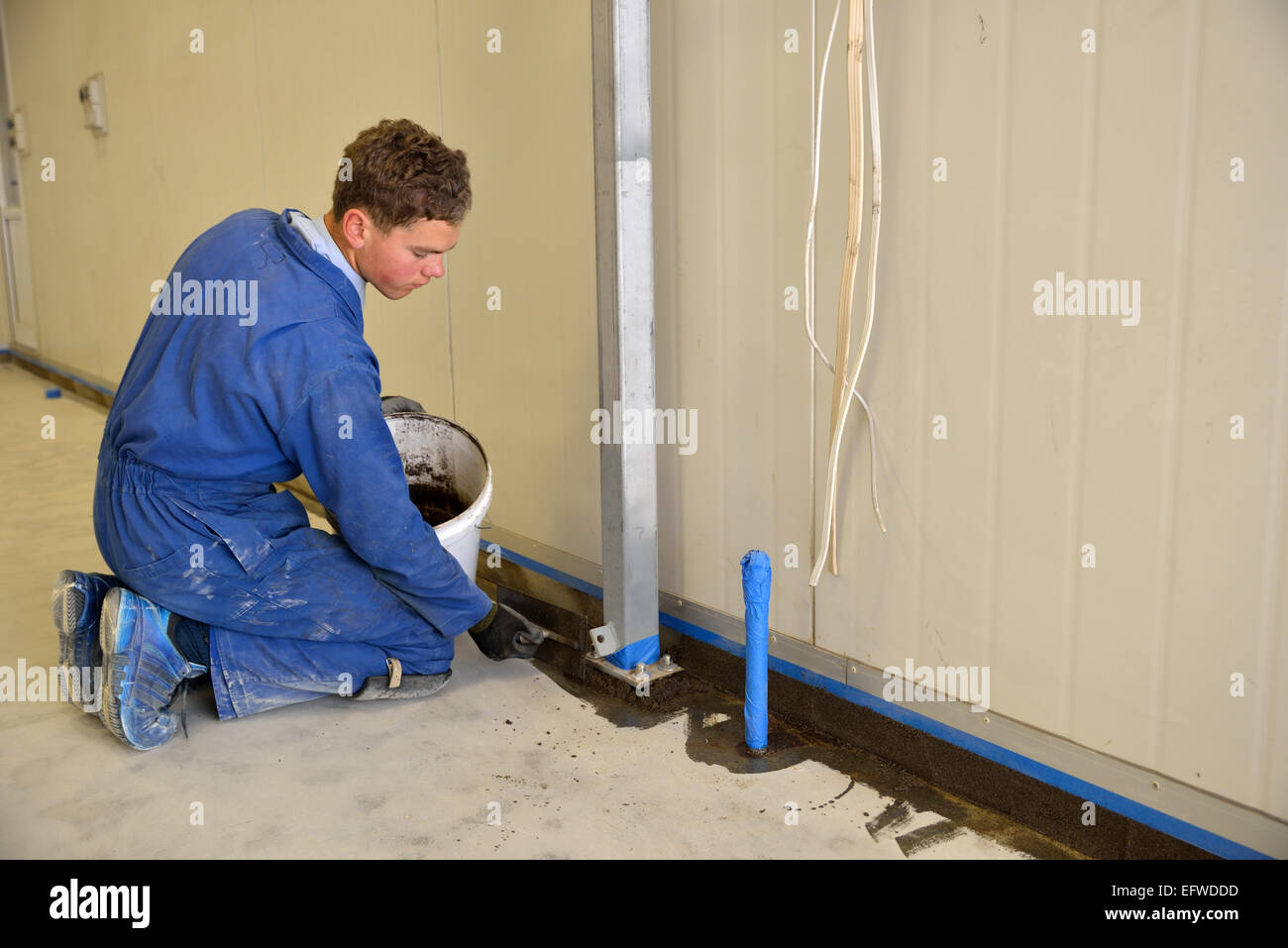 An Apprentice Tradesman Uses A Special Trowel To Apply Epoxy