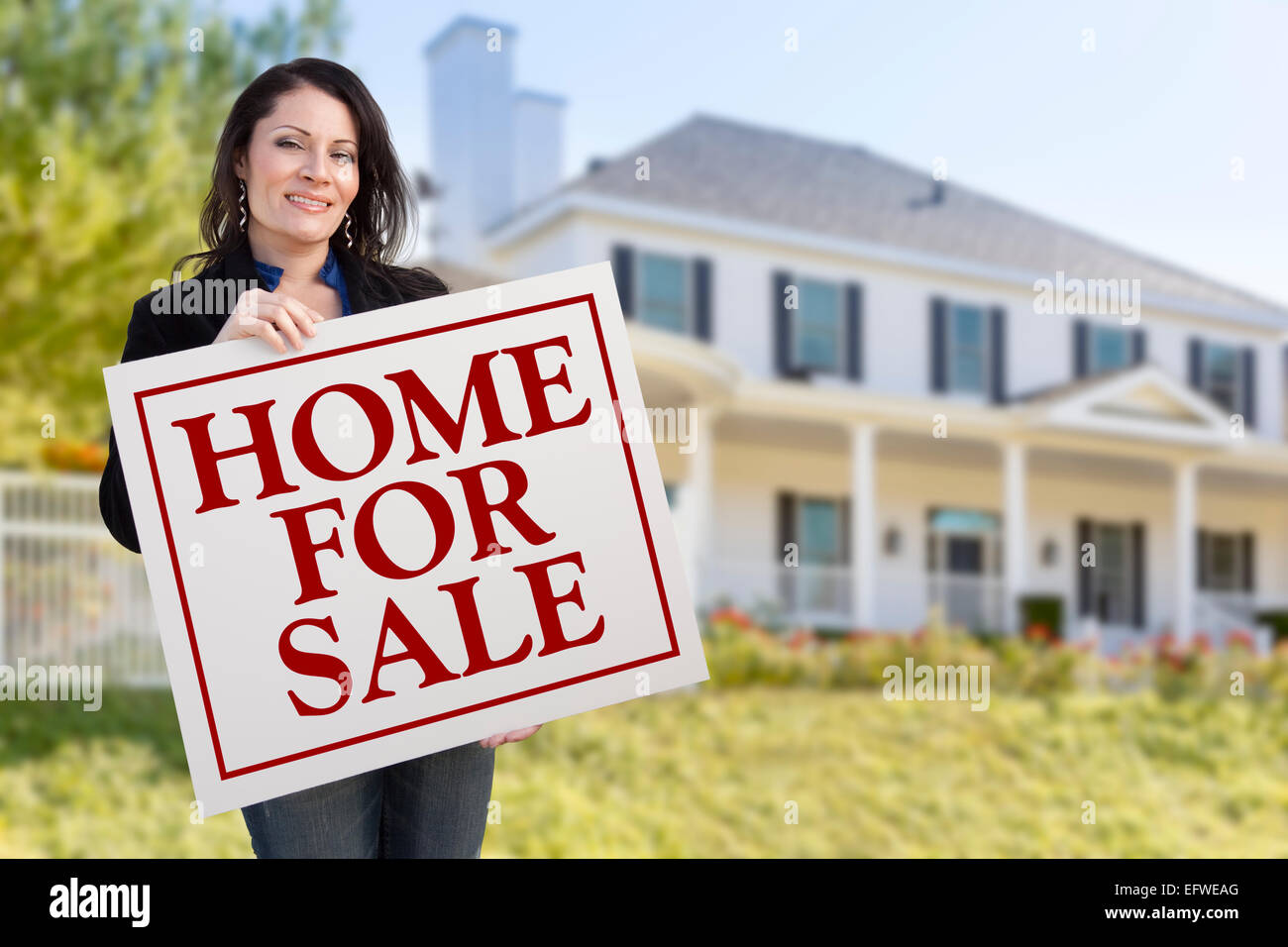Smiling Hispanic Female Holding Sold For Sale Sign In Front of ...