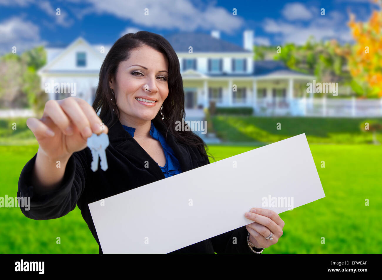 Hispanic Woman Holding Blank Sign and Keys In Front of Beautiful House ...