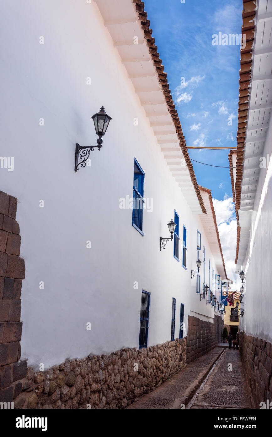 Narrow street with white colonial buildings in the center of Cuzco, Peru Stock Photo