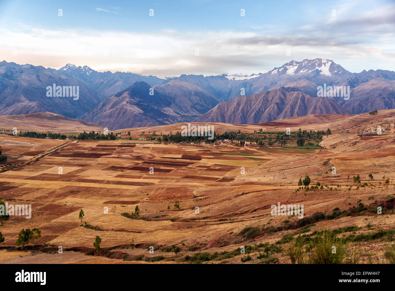 View of fields in the Sacred Valley near Cusco, Peru with Andes mountains rising over it Stock Photo