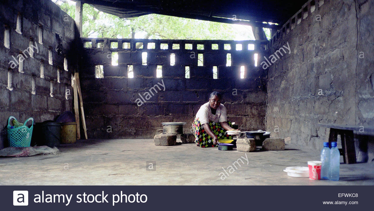 Woman Cooking In Makeshift Kitchen For Mechanics Using Charcoal