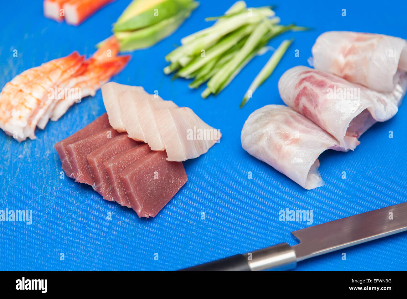 Japanese seafood ready for sushi on blue chopped board Stock Photo
