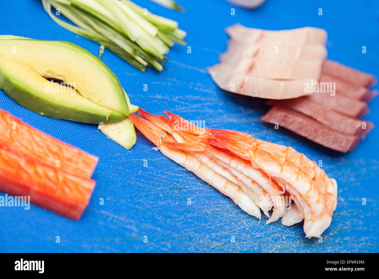 Japanese seafood ready for sushi on blue chopped board Stock Photo