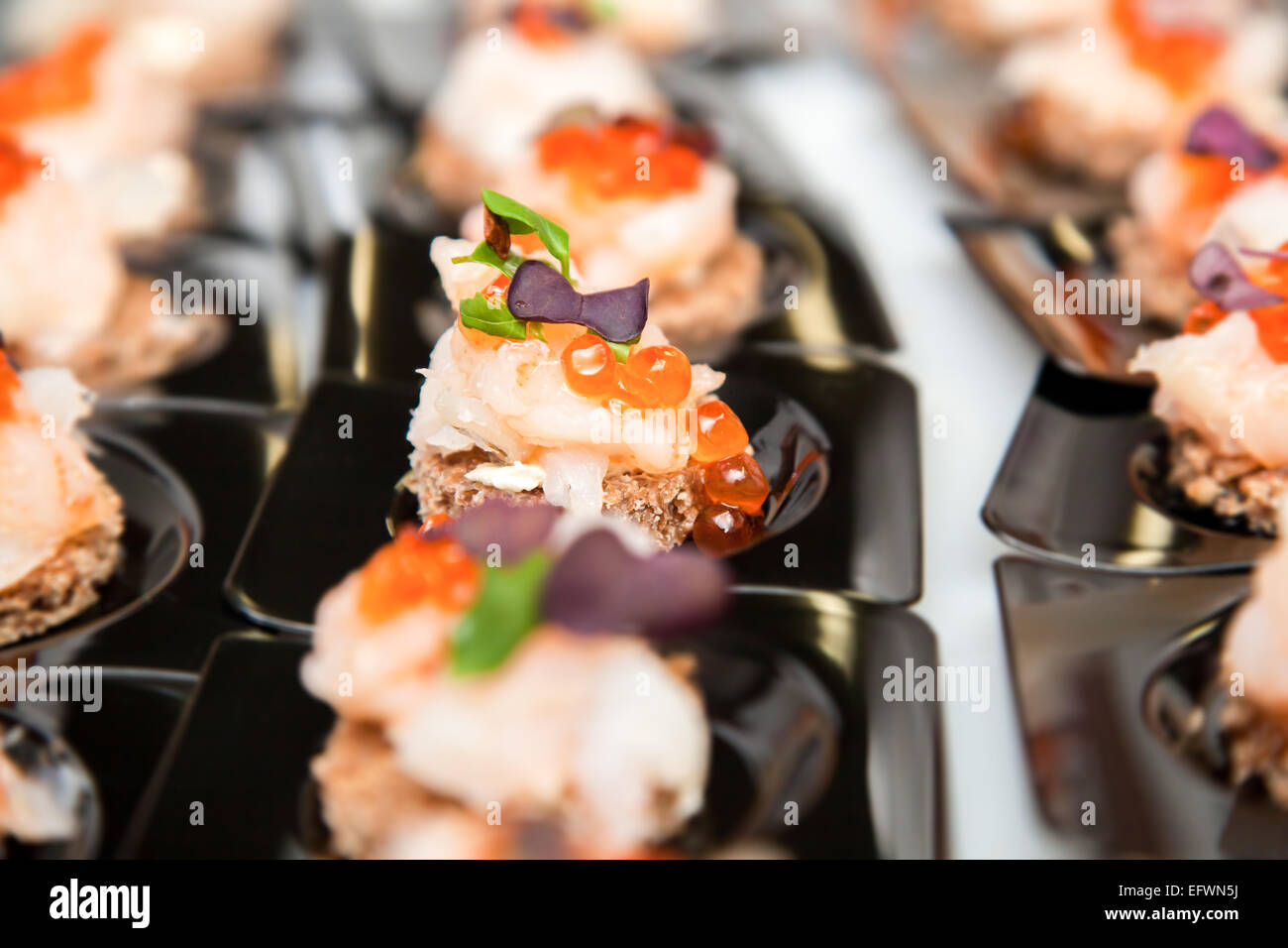 Appetizer of Salmon eggs, fish, and green herbs canapés Stock Photo