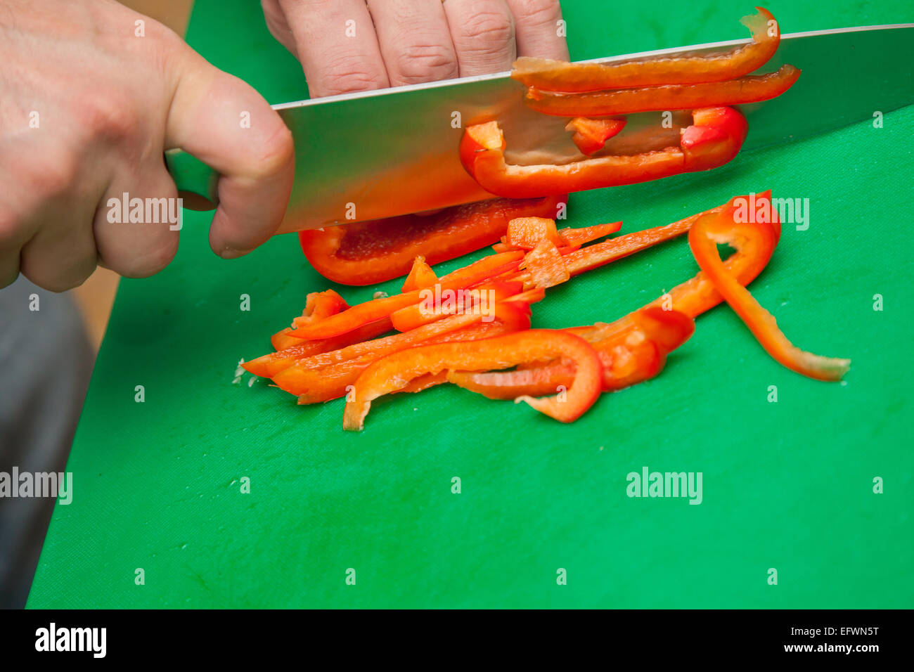 Food Preparation - Cutting a Red Bell Pepper Stock Photo