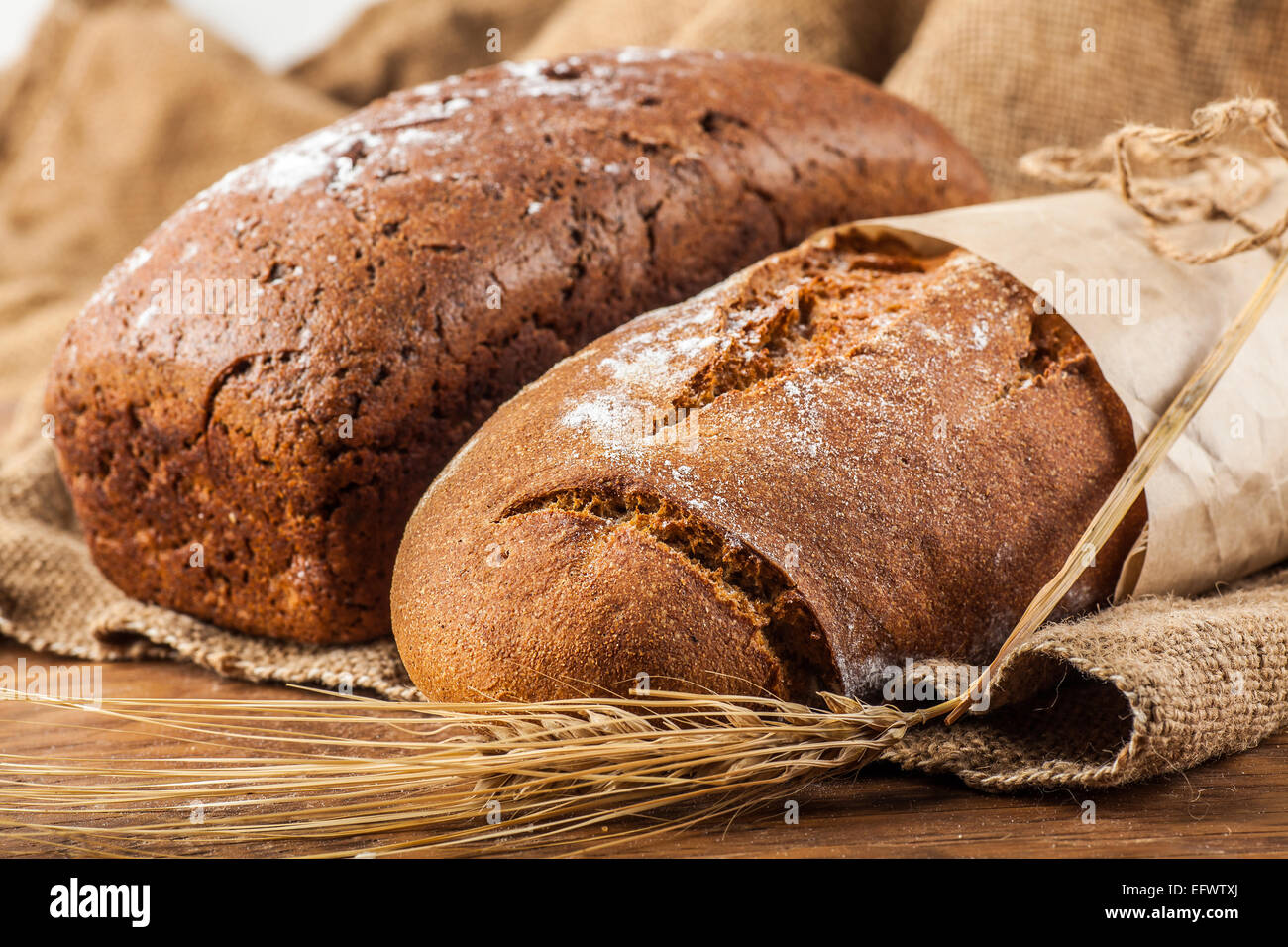 two bread with ears of wheat on the wooden background Stock Photo Alamy