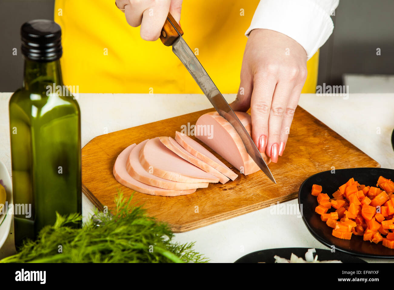 cook knife cuts sausage, near vegetable ingredients Stock Photo Alamy