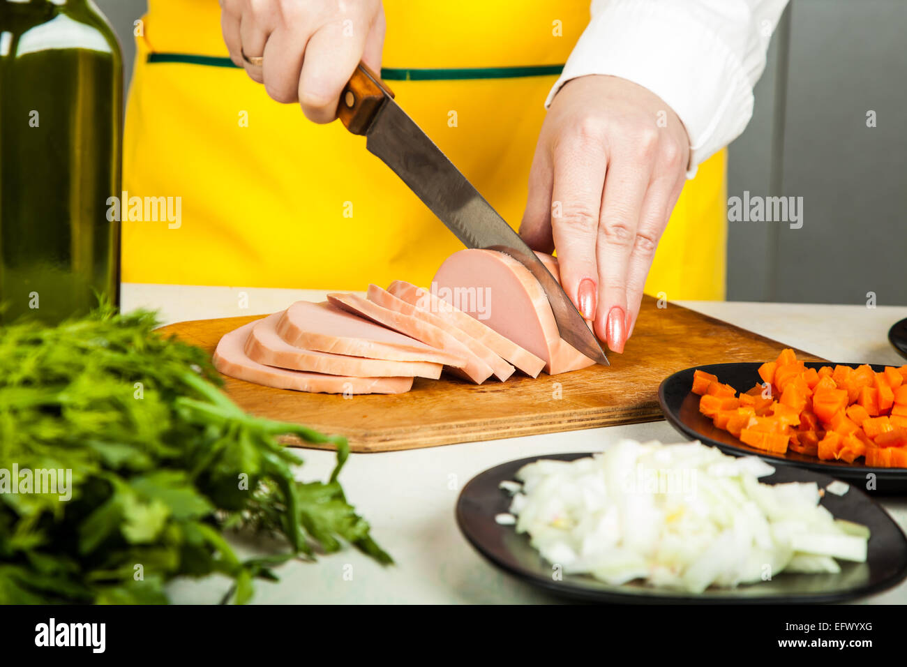 cook knife cuts sausage, near vegetable ingredients Stock Photo Alamy