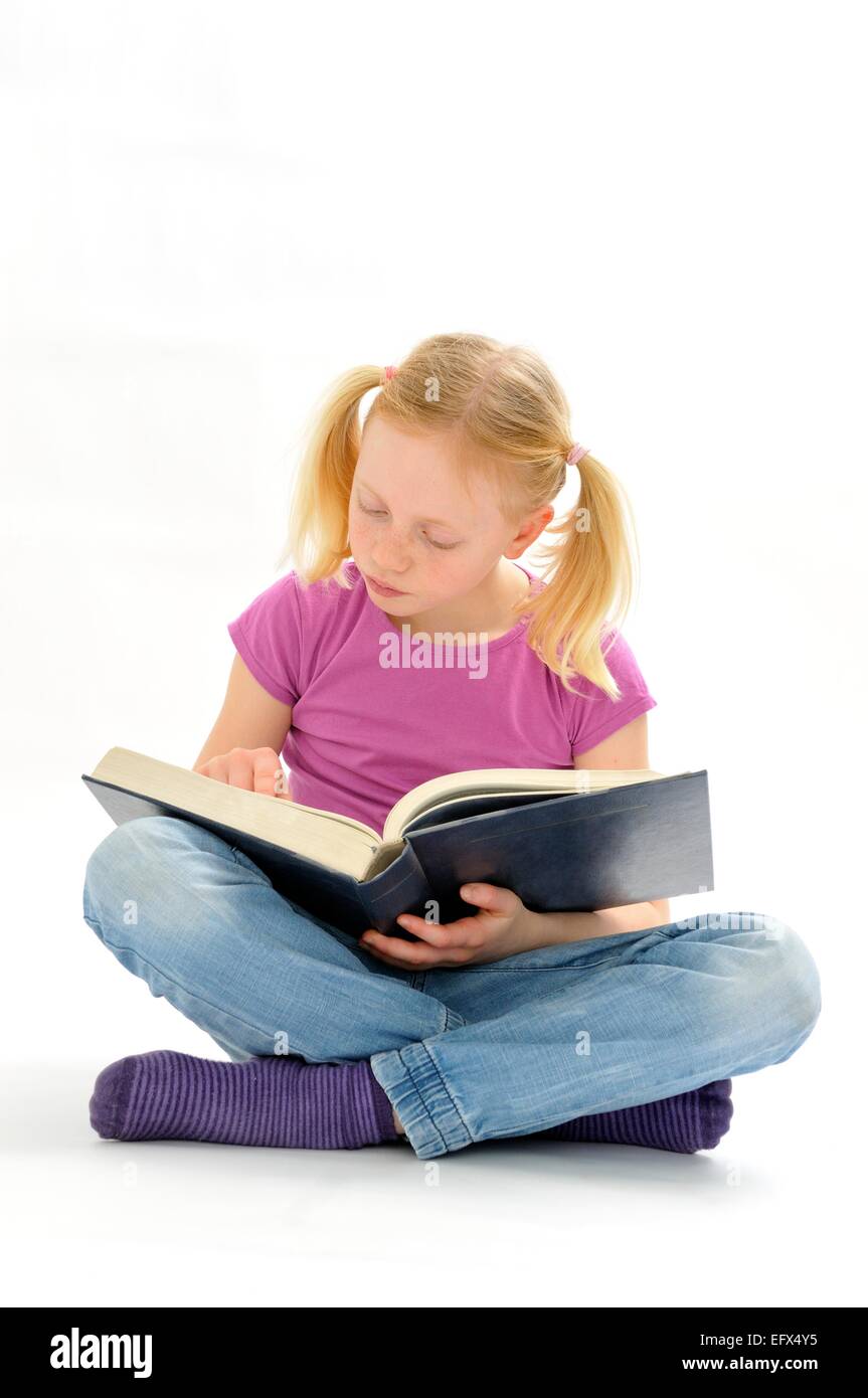 Pre teen girl reading a large book Stock Photo