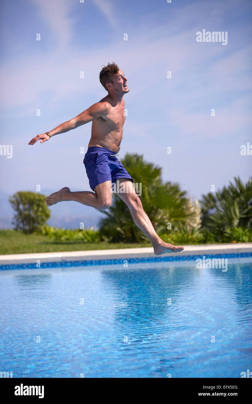 Young man jumping in the pool Stock Photo