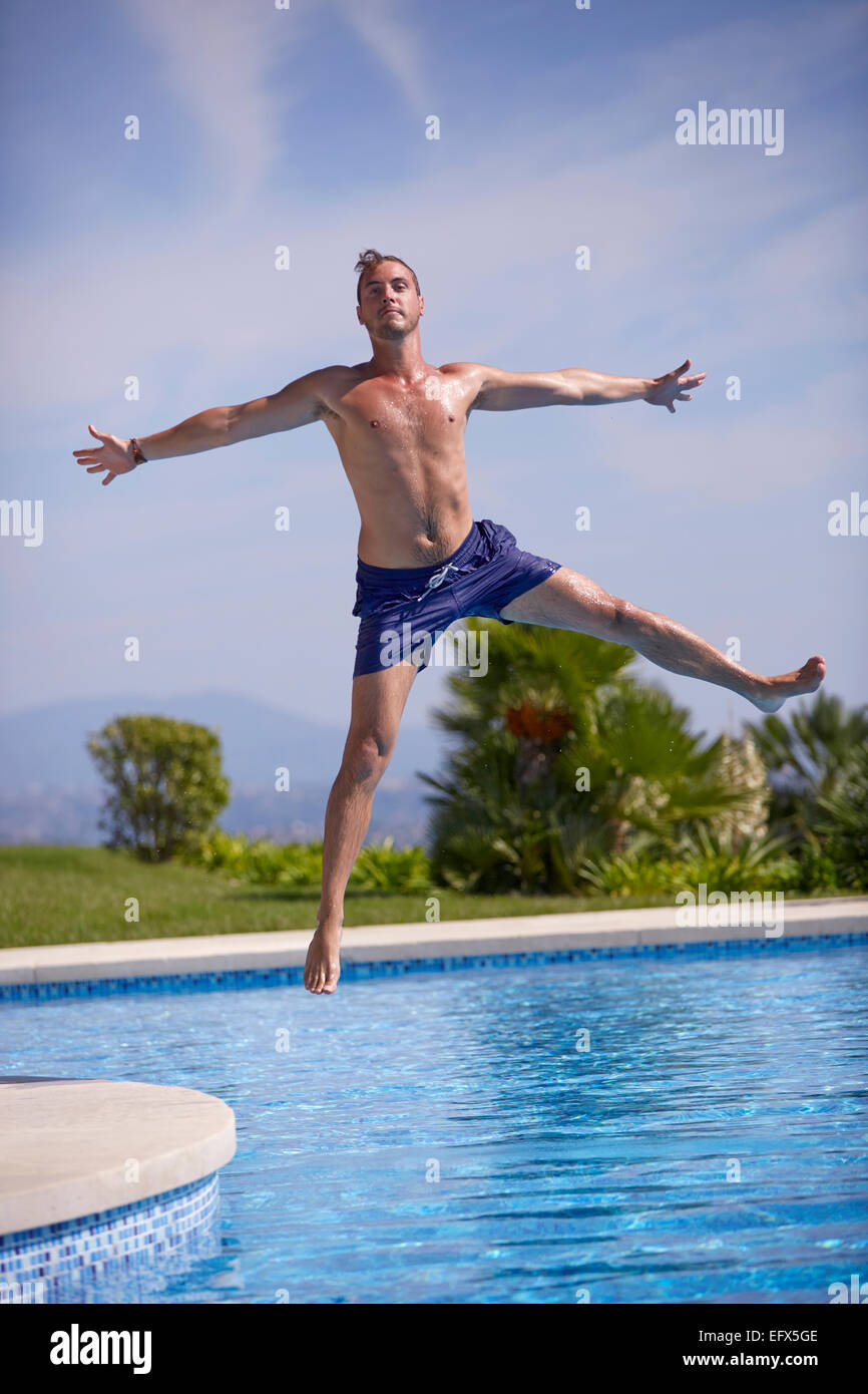Young man jumping in the pool Stock Photo