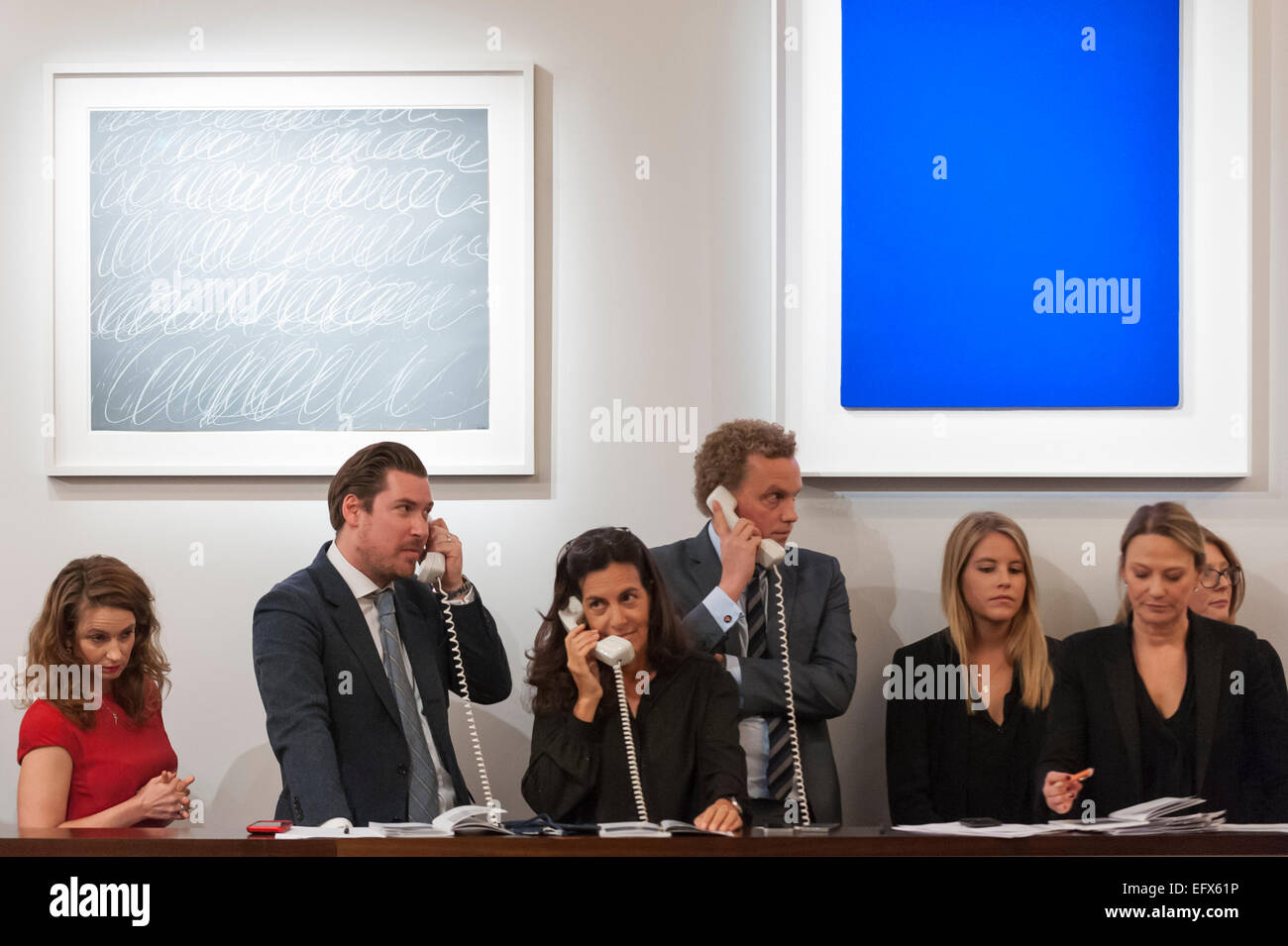 Sotheby's, London, UK. 10 February 2015. In front of (L to R) Cy Twombly's 'Rome', sold for £3.085m and Yves Klein's 'Untitled Blue Monochrome (IKB 92)',  sold for £6.085m, Sotheby's staff place bids for their telephone clients.  The evening sales total was £122.6 million, the highest-ever for a Sotheby's sale of Contemporary Art in Europe. Credit:  Stephen Chung/Alamy Live News Stock Photo