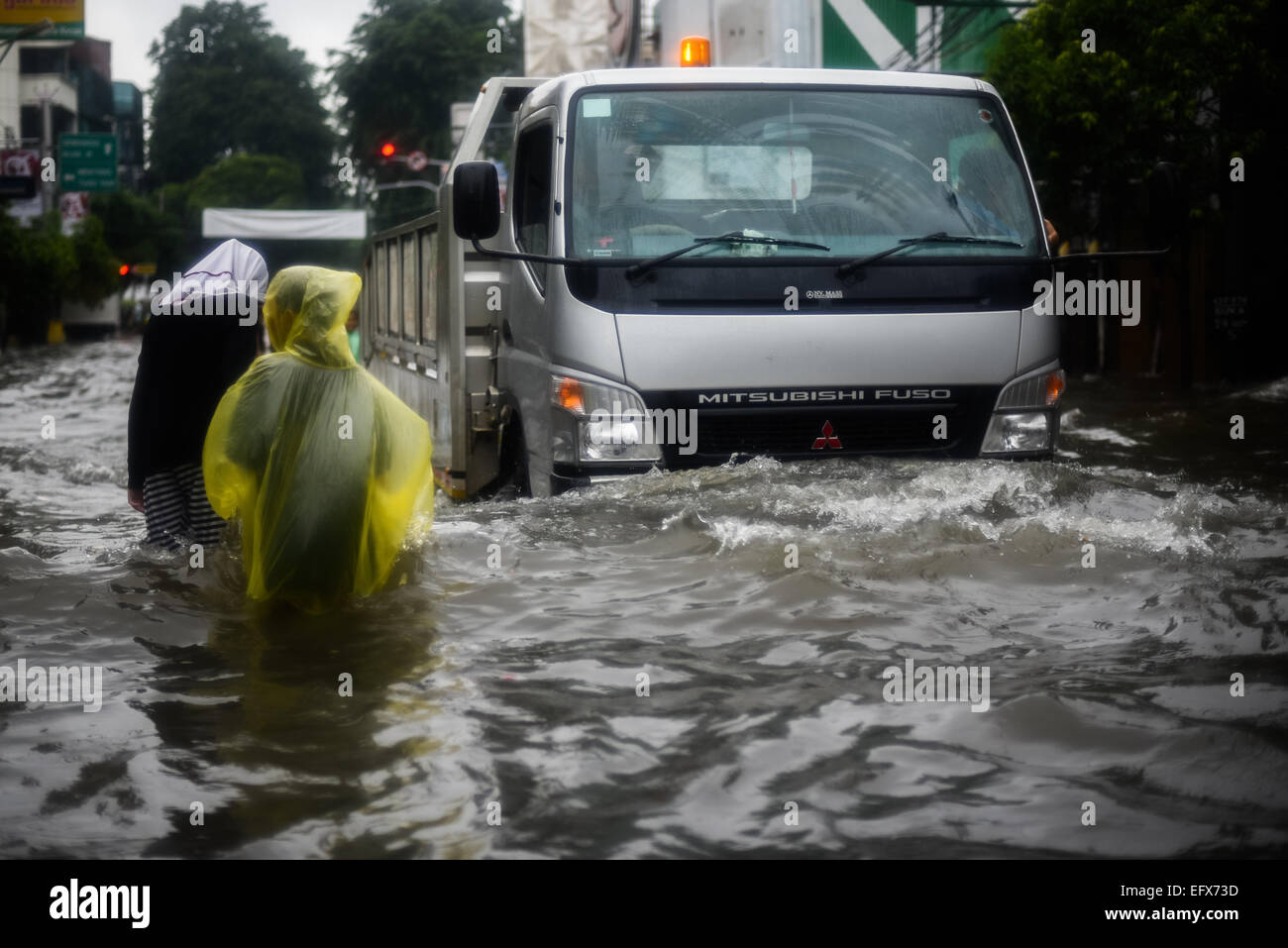 People and a truck moving through floodwater in Jakarta, after a continuous rain left the downtown area of the Indonesian capital city flooded. Stock Photo