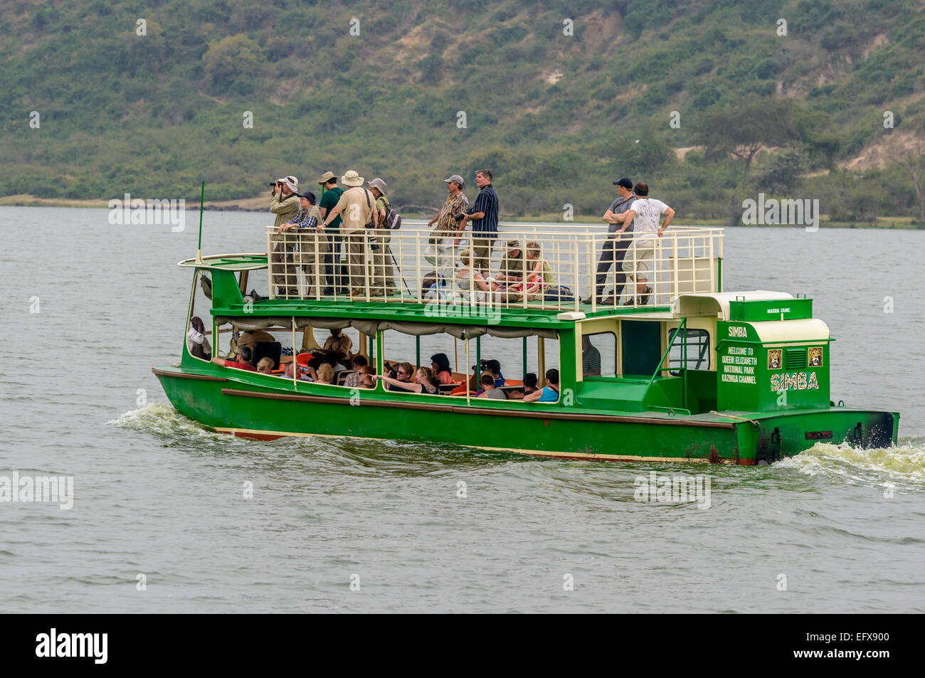 Tourists on a wildlife-spotting boat trip around Lake Edward, QENP, Uganda. From behind. Stock Photo