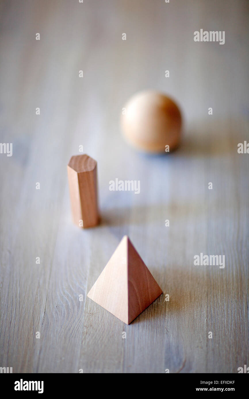 three simple objects that are all different 3d shapes. They are made of wood Stock Photo