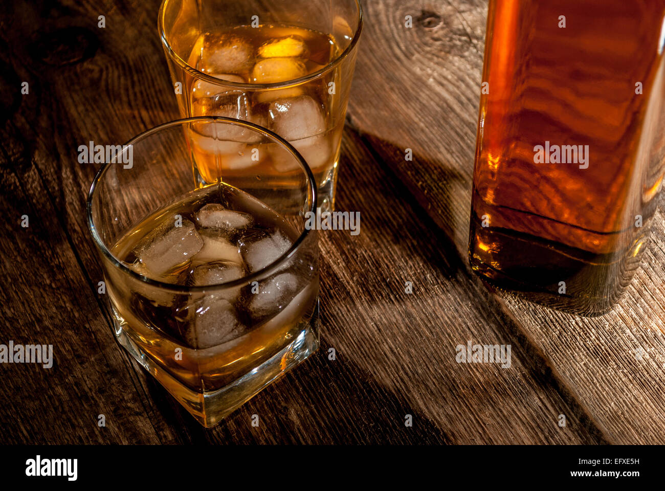 Whiskey, bourbon or brown rum with ice on wood table Stock Photo