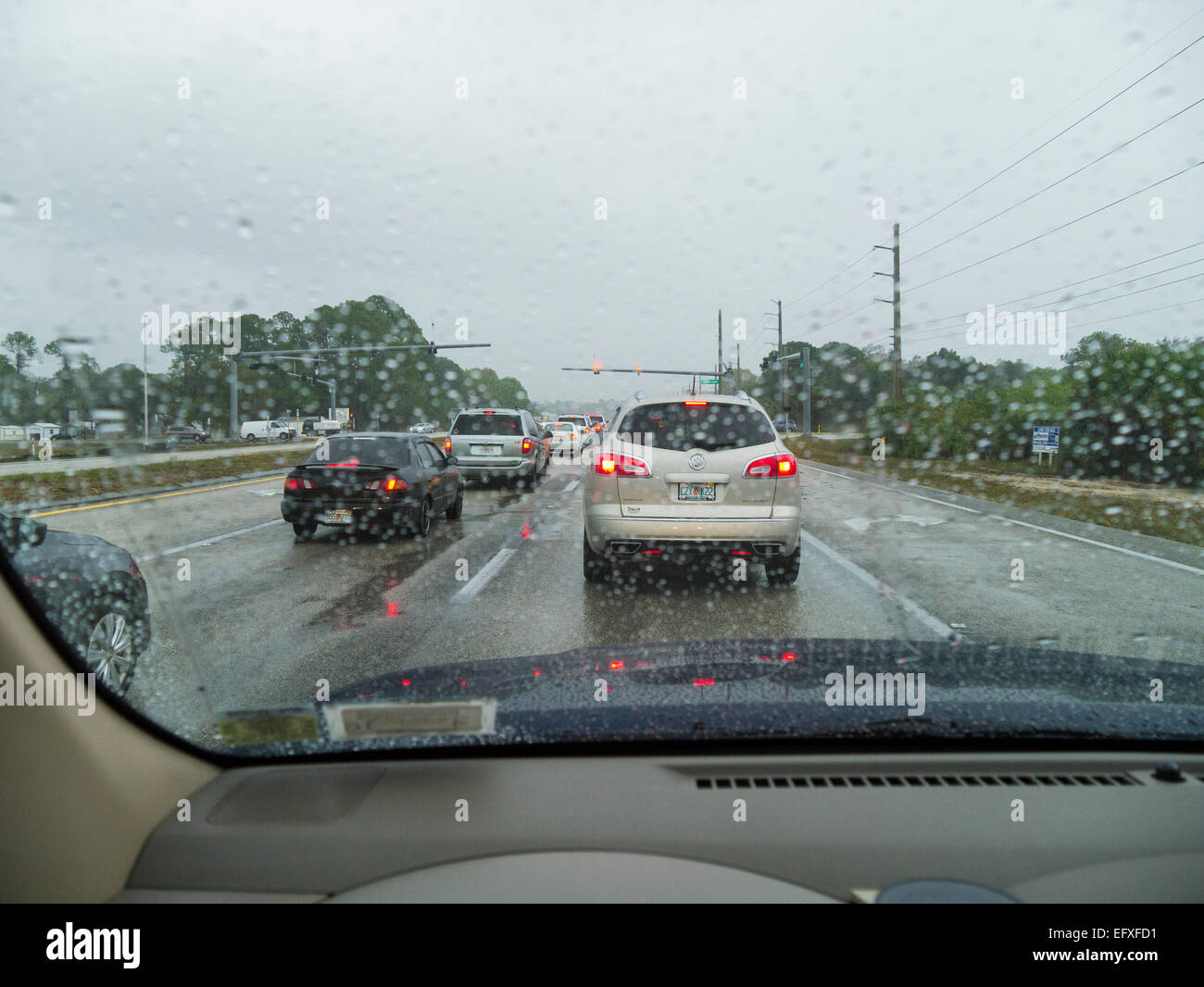 Traffic stopped at traffic light on a rainy overcast day Stock Photo