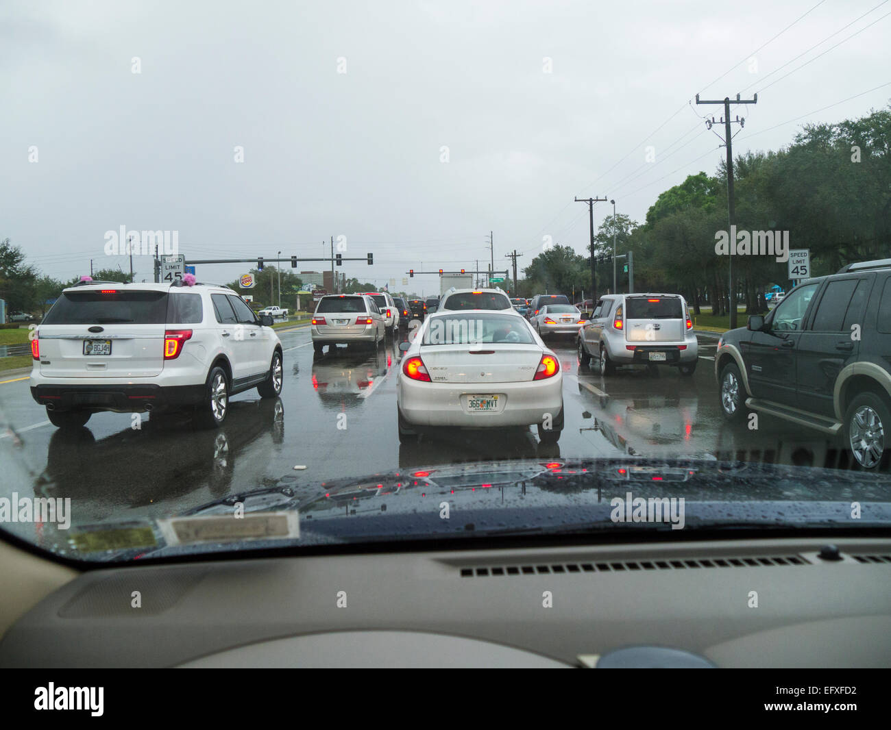Traffic stopped at traffic light on a rainy overcast day Stock Photo