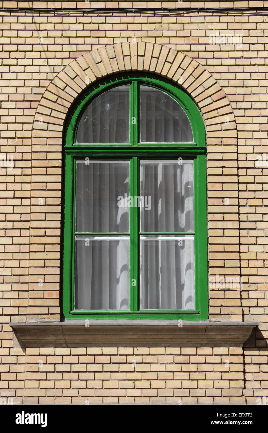Detailed view of an arched window on a red bricks building Stock Photo