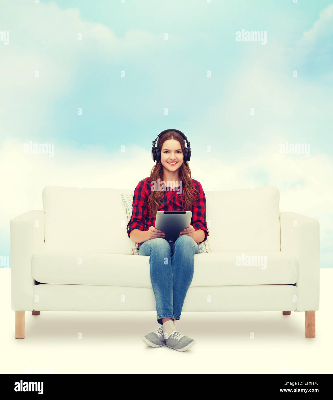girl sitting on sofa with headphones and tablet pc Stock Photo - Alamy