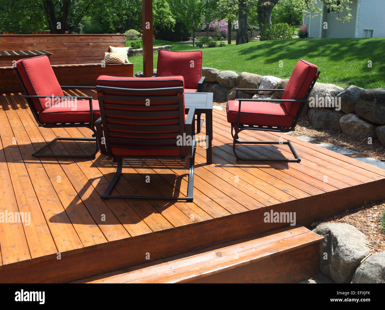 A stained backyard deck with deck chairs. Stock Photo