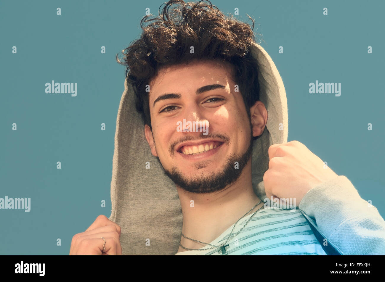 a boy with hood looks in camera and laughs Stock Photo