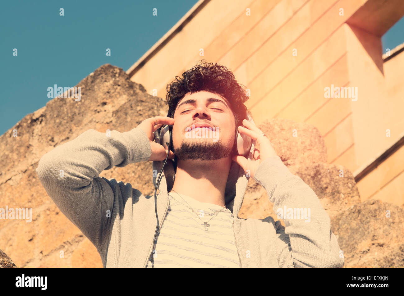 boy listening to music in an urban setting Stock Photo