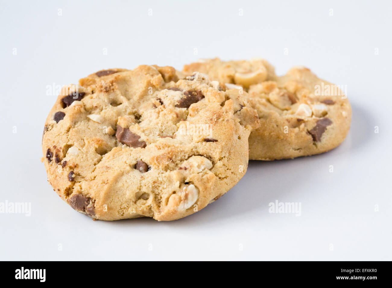 Two chocolate chip and nut cookies on a white background. Stock Photo